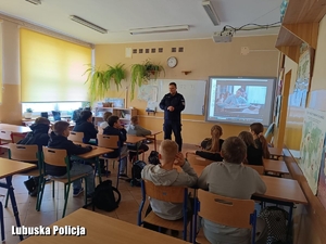 Policjant podczas akcji profilaktycznej w klasie szkolnej.