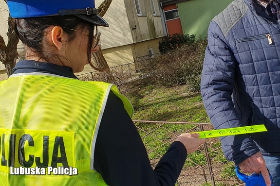 Policjantka przekazuje odblask innej osobie