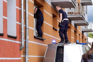 Policjanci wchodzą przez okno do mieszkania