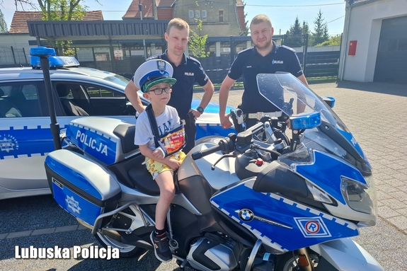 Policjanci wraz z chłopcem na motocyklu