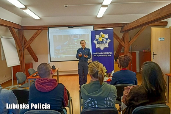 Policjantka rozmawia z zebranymi w sali