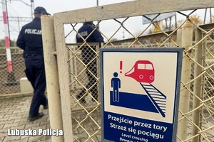 Tabliczka informacyjna, w tle widoczni policjanci
