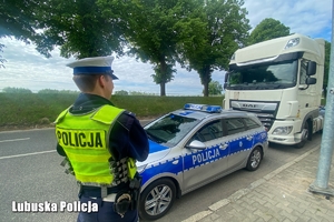 Policjant patrzący na samochód ciężarowy