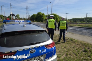 Policjanci, w tle widoczny przejazd kolejowy