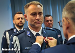Wojewoda Lubuski wręcza odznaczenie policjantowi.