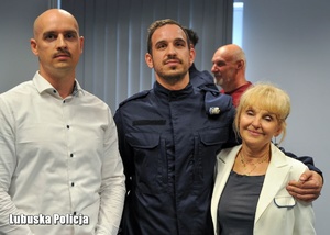 Policjant pozuje do zdjęcia z rodziną.