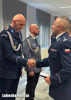 Komendant Wojewódzki Policji gratuluje policjantowi odznaczenia.