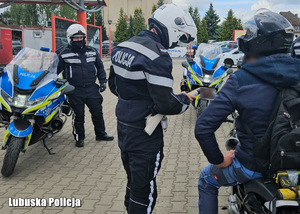 Policjant kontroluje motocyklistę.