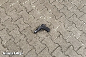 Pistolet znajdujący się na chodniku.