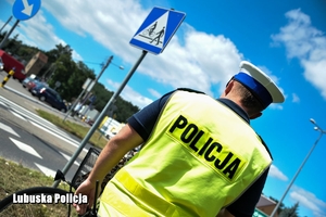Policjant stojący przy przejeździe rowerowym.
