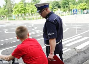 Policjant z chłopcem podczas egzaminu na kartę rowerową.