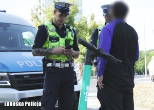 Policjanci podczas kontroli drogowej mężczyzny z hulajnogą.