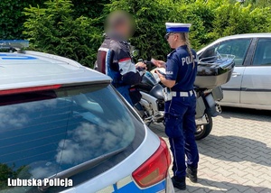 Policjanci podczas kontroli drogowej motocyklisty.