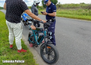 Policjanci podczas kontroli drogowej motorowerzysty.