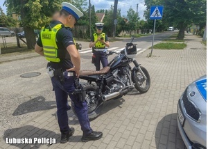 Policjanci podczas kontroli drogowej motocyklisty.