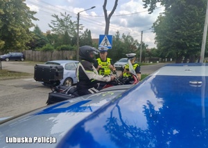 Policjanci podczas kontroli drogowej motocyklisty.