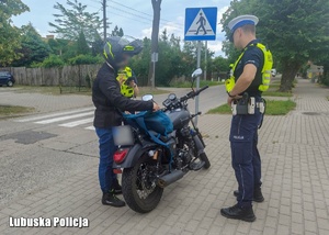 Policjanci podczas kontroli drogowej motocyklisty.