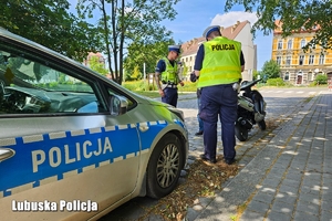 Policjanci podczas kontroli drogowej motocyklisty.