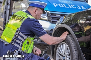 policjant kontroluje ogumienie pojazdu