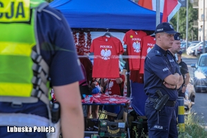 policjanci stoją przy straganie z koszulkami