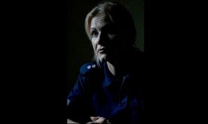 policjantka siedzi w ciemnym pomieszczeniu