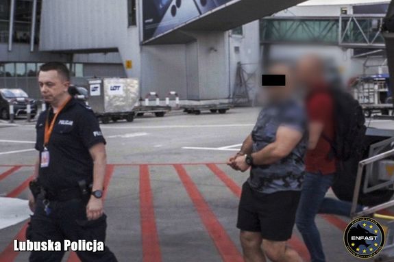 Mężczyzna  transportowany przez policjantów.