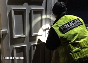policjant prowadzi oględziny drzwi