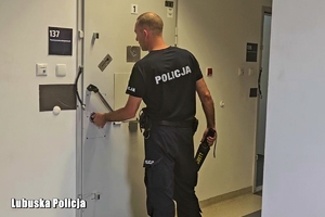 policjant otwiera drzwi