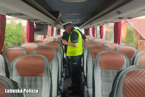 Policjant kontroluje stan techniczny autokaru