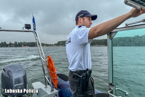 policjant na łodzi obserwuje jezioro