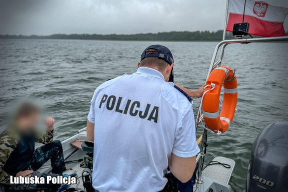 policjant na łodzi legitymuje mężczyznę