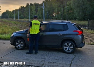 Policjant sprawdza stan trzeźwości kierującego samochodem.