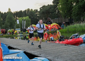 Policjanci biegną po drewnianym pomoście