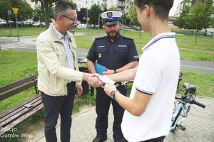 Mężczyzna gratuluje chłopcu podczas egzaminu na kartę rowerową.
