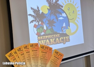 Ulotki profilaktyczne na tle wyświetlacza projektora.