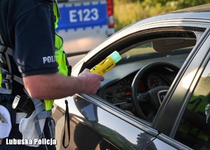 Policjant sprawdza trzeźwość kierującego.