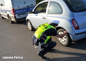 Policjant podczas przeprowadzania kontroli drogowej.