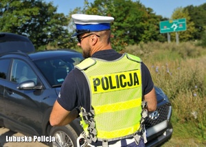Policjant podczas przeprowadzania kontroli drogowej.