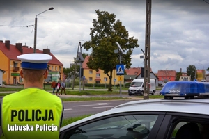 Policjant ruchu drogowego patrzy w kierunku przejścia dla pieszych.