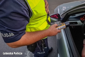 policjant kontroluje trzeźwość kierowcy