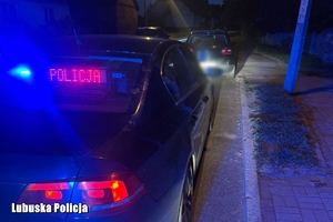radiowóz stoi za samochodem osobowym