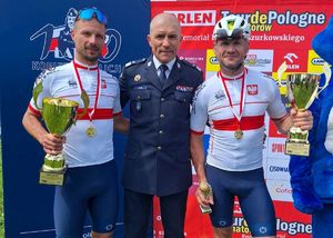 Pierwszy Zastępca Komendanta Głównego Policji pozuje do zdjęcia z policjantami - kolarzami.