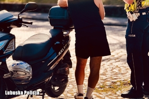 policjant stoi przy motocykliście