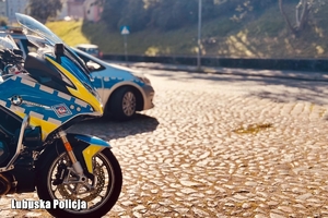 radiowóz i motocykl przy drodze
