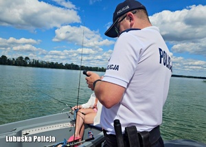 Policjant podczas legitymowania osoby na łódce.