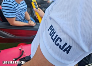 Policjant podczas sprawdzania stanu trzeźwości osoby na łódce.