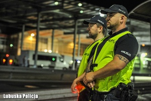 Policjanci stoją w obrębie przejścia granicznego.