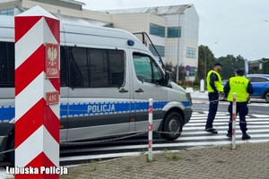 Policyjny radiowóz i policjanci na przejściu granicznym.