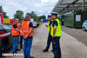 Policjanci rozmawiają z mężczyznami na przejściu granicznym.