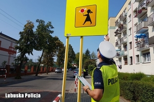 policjantka sprawdza oznakowanie na drodze